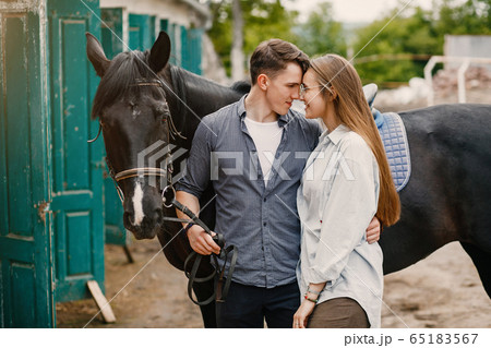 Cute loving couple with horse on ranch 65183567
