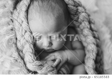 portrait of a little girl in a wool blanket. imitation of the umbilical cord, a baby in the womb. close-up of the child's face. concept of childhood, health care, IVF portrait of a little girl in a wool blanket. imitation of the umbilical cord, a baby in the womb. close-up of the child's face. concept of childhood, health care, IVF 65185583