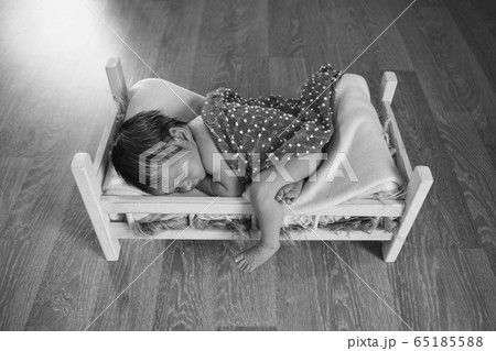 baby lying in a wooden bed under a blanket. portrait of little child. the concept of childhood, health, IVF, children's furniture, interior, wood products baby lying in a wooden bed under a blanket. portrait of little child. the concept of childhood, health, IVF, children's furniture, interior, wood products 65185588