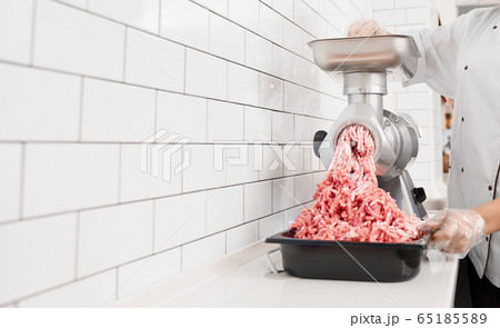 Incognito female butcher doing minced meat. Incognito female butcher doing minced meat. 65185589