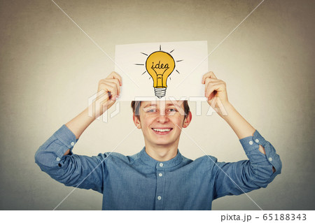 Smiling teenager boy holding a paper sheet with a 65188343