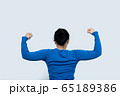 Portrait of a happy woman showing her biceps on 65189386