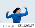 Portrait of a happy woman showing her biceps on 65189387