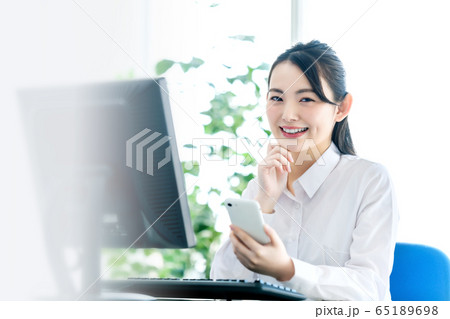 オフィス 女性 スマホ パソコン デスクワーク オフィス 女性 スマホ パソコン デスクワーク 65189698