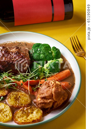 Rare roast beef meal with organic root vegetables and traditional Yorkshire pudding with sauce, stewed vegetables. 65190849