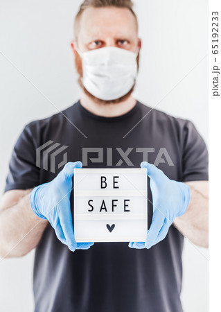 Man holding lightbox with text Be safe in his hand 65192233