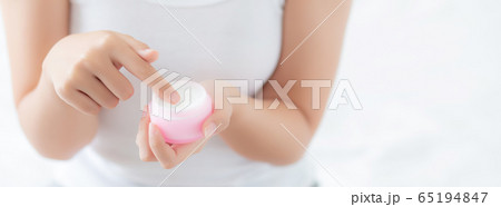 Beautiful with closeup hand asian woman applying moisturizer or lotion skin care cream cosmetic 65194847