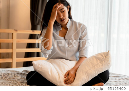 Portrait of 20s young Asian woman suffering pain and medical sickness in bedroom at night. Fever, high temperature, cold, migraine, tiredness, symptoms 65195400