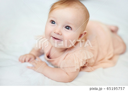 Portrait of a sweet infant smile wearing a pink dress in studio 65195757