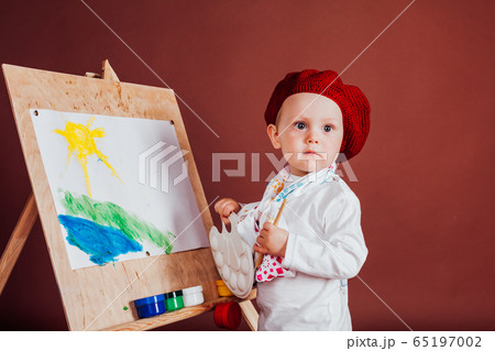 little boy artist brush and paints paints a picture 65197002