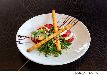 Caprese salad with buffalo mozzarella. Dark background. Close-up. 65197358