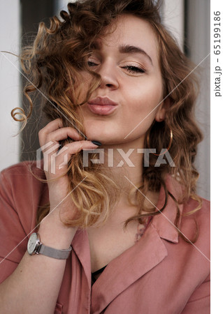 Beautiful funny pretty curly lady positive good mood sending air kisses 65199186