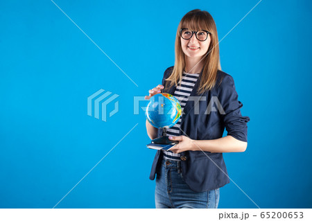 travel agent girl with passports tickets and globe on a blue background. travel agent girl with passports tickets and globe on a blue background. 65200653