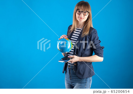 travel agent girl with passports tickets and globe on a blue background. 65200654