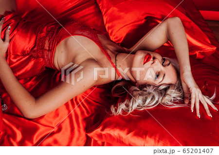 sexy blonde in red underwear lies on a bed sexy blonde in red underwear lies on a bed 65201407