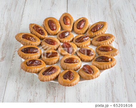 Homemade Eid Dates sweets on a white wooden table 65201616