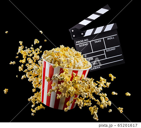 Flying popcorn and film clapper board isolated on black background 65201617