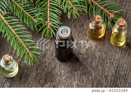 A bottle of essential oil with spruce branches 65203284