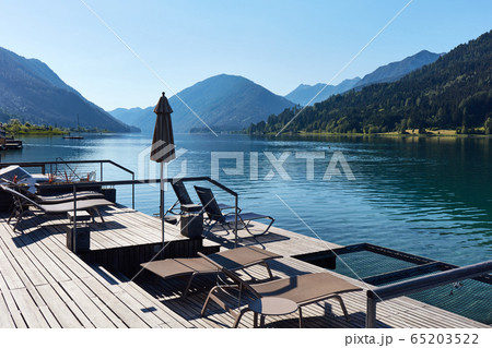 Hotel terrace with deck chairs on the shores of an 65203522