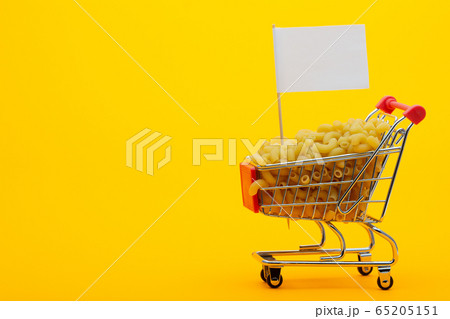 The grocery cart is filled with pasta on a bright 65205151