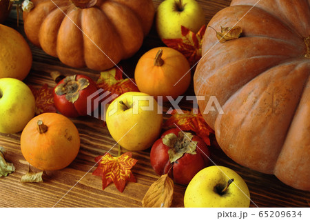 A bunch of pumpkins and apples. 65209634
