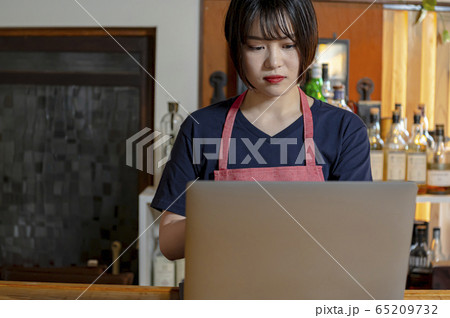 居酒屋 発注 帳簿付けする女性店員の写真素材