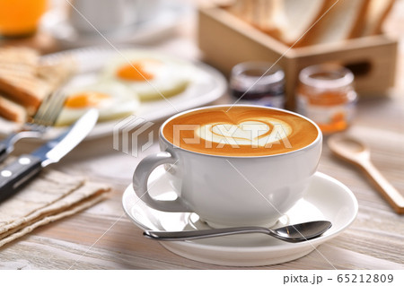 Cup of coffee latte with breakfast on wooden table Cup of coffee latte with breakfast on wooden table 65212809