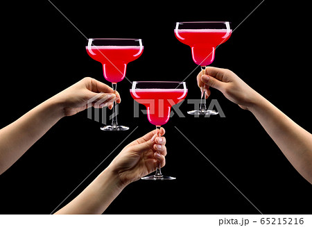 Set of hands holding strawberry margarita glass isolated on black. 65215216