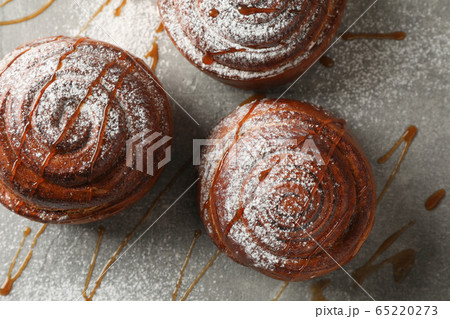 Cinnamon rolls with caramel and powdered sugar on Cinnamon rolls with caramel and powdered sugar on 65220273