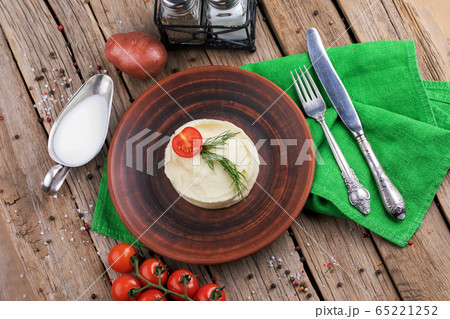 Mashed potatoes in plate on wooden table 65221252