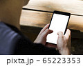 Photo of man sitting outside at wooden table 65223353