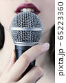 Close up of a young woman with red lips holding 65223360