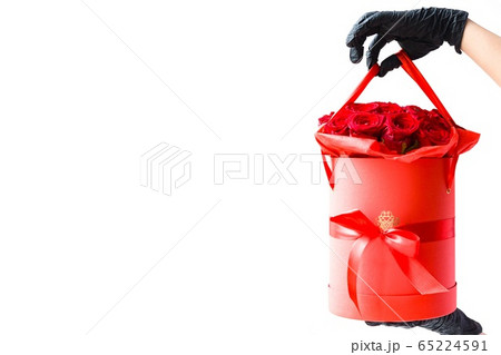 Hands in black medical gloves with red roses  65224591