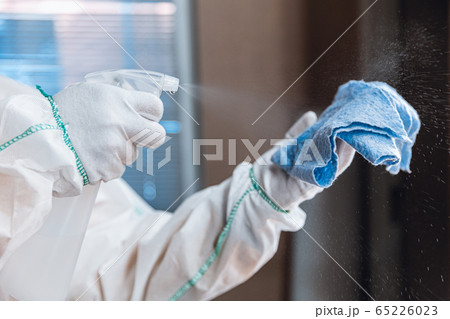 Coronavirus Pandemic. A disinfector in a protective suit and mask sprays disinfectants in the house or office 65226023