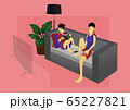 a boy reading book and a woman watching TV on sofa 65227821