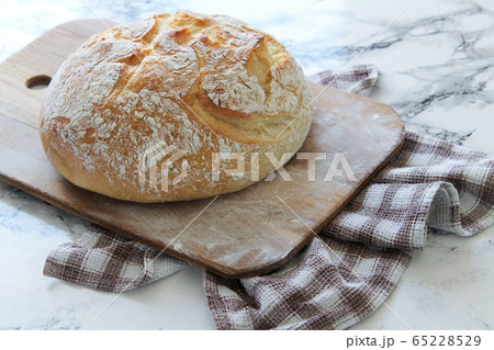 Freshly baked homemade crisp bread on rustic wooden board on a linen napkin Freshly baked homemade crisp bread on rustic wooden board on a linen napkin 65228529