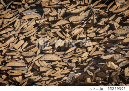 A pile of firewood, firewood wall of an old wooden house, preparation of firewood for the winter. 65229395