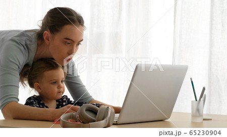 Mother and little daughter using laptop at home Mother and little daughter using laptop at home 65230904