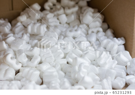 Red felt heart packaging box filled with many white styrofoam pellets.  65231293