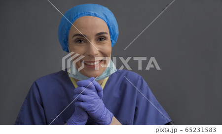 Happy doctor looks at camera. Young nurse smiling happily Joining hands together. Selective Focus on female hands in the foreground Happy doctor looks at camera. Young nurse smiling happily Joining hands together. Selective Focus on female hands in the foreground 65231583