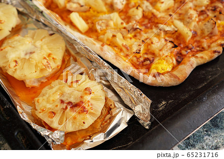 Chicken fillet with pineapples on foil and homemade Hawaiian pizza 65231716
