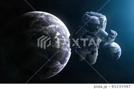 Astronaut on background of exoplanets in light of blue star Astronaut on background of exoplanets in light of blue star 65235497