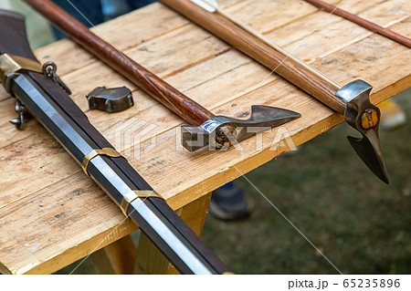 pair of long-handled axes and a black gun 65235896