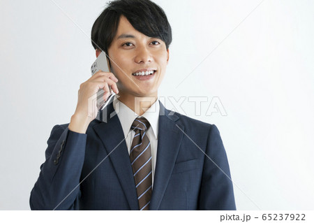 スマートフォンで通話する若い男性 65237922