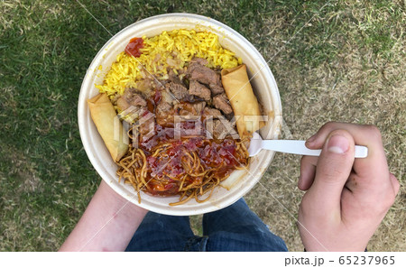 Street Food from a festival food truck being eaten by hungry festival visitor 65237965