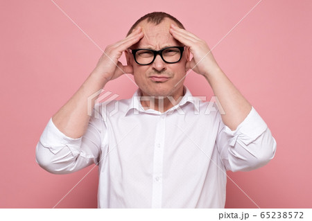 Stressed young man in eyeglasses regretting about something, looking at camera. Stressed young man in eyeglasses regretting about something, looking at camera. 65238572