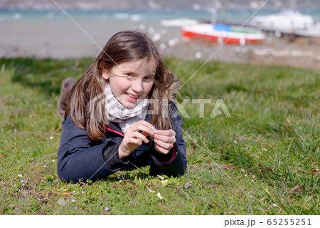 pretty preteen is lying in the green grass pretty preteen is lying in the green grass 65255251