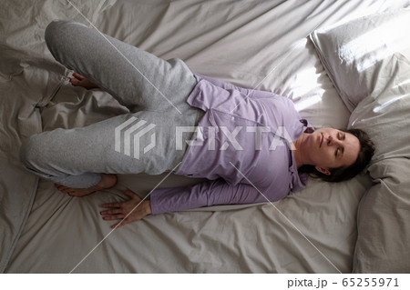 Young woman in ardha chakrasana yoga pose on bed in the morning Young woman in ardha chakrasana yoga pose on bed in the morning 65255971