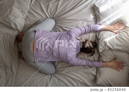caucasian woman working out at home doing Child pose, Balasana on the bed. caucasian woman working out at home doing Child pose, Balasana on the bed. 65256040