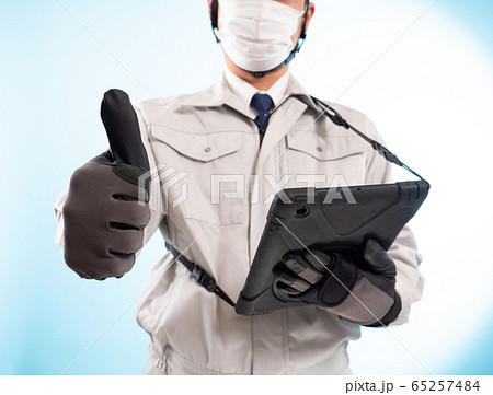 タブレット端末とマスクをはめた作業員（サムアップ） 65257484